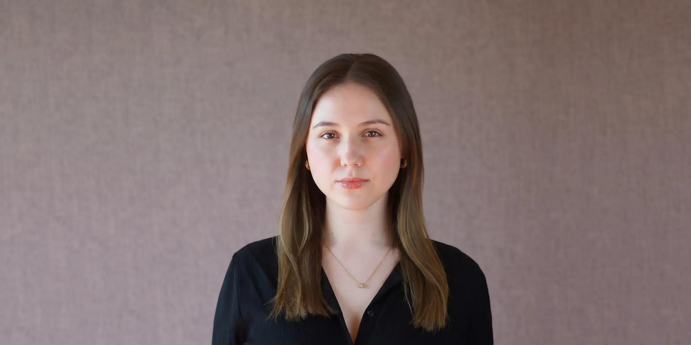 Gabriela Sarosiek, founder of Bright Noise, in a black shirt against a soft mauve wall